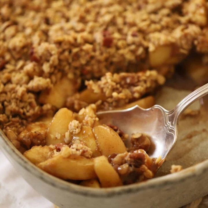 Apple crisp with a large serving spoon scooping out a portion