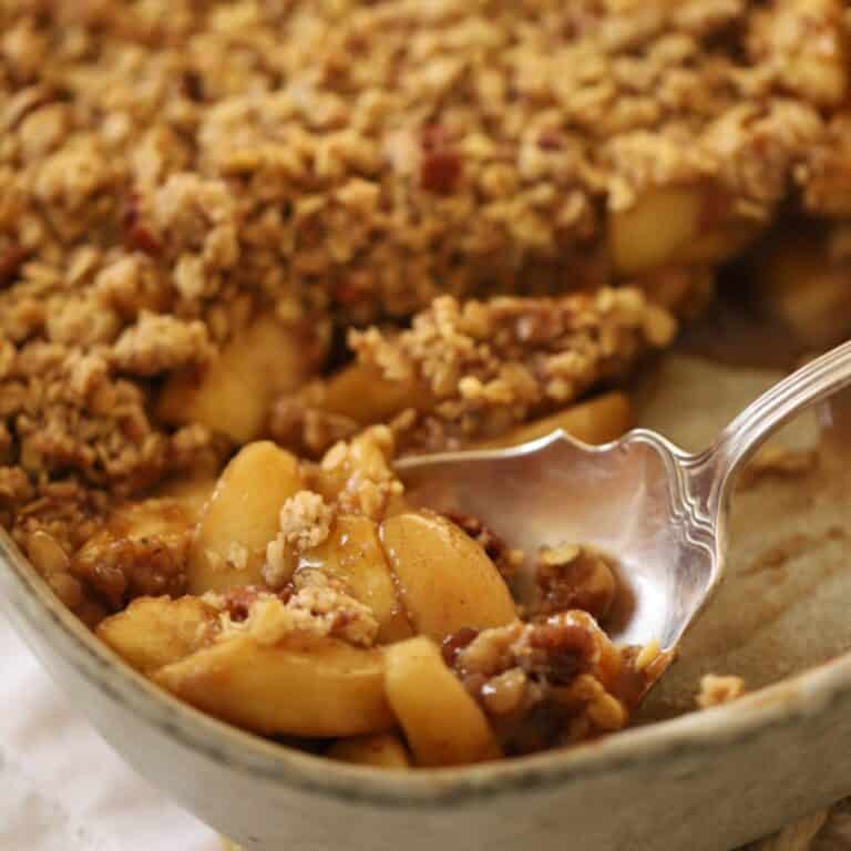 Apple crisp with a large serving spoon scooping out a portion
