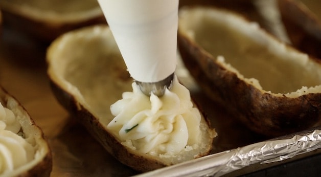 Piping mashed potato in a potato shell
