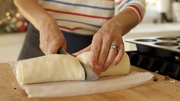 slicing a log of puff pastry dough in half