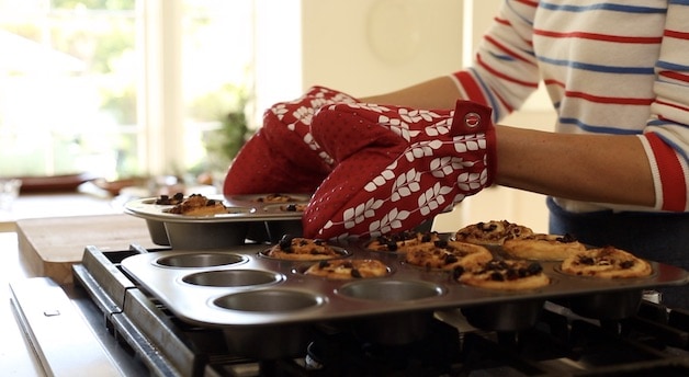 Placing sticky bun trays on the cooktop to cool