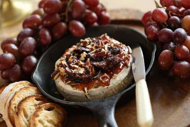 Baked Brie with Jam in a Cast Iron Skillet with Grapes and Toasts
