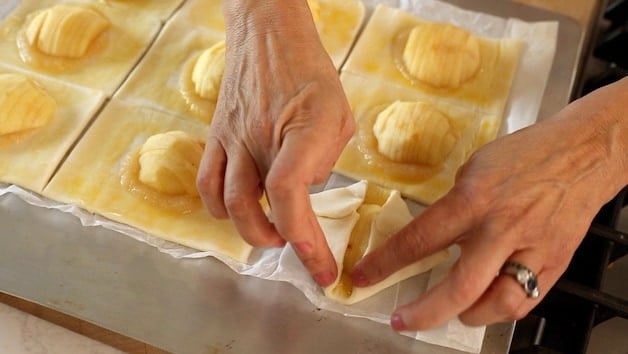 Folding up corners on puff pastry apple squares