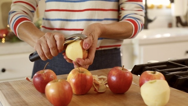 A person sitting at a table in front of an apple