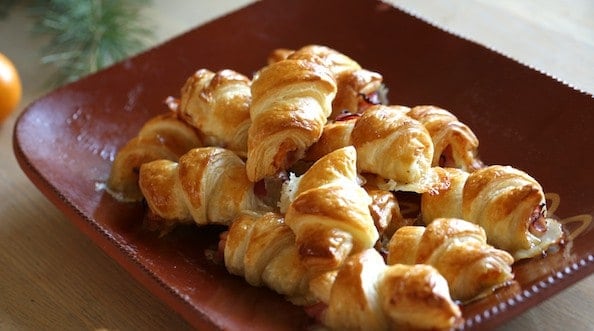 A terra-cotta platter of mini Ham and Cheese Croissants
