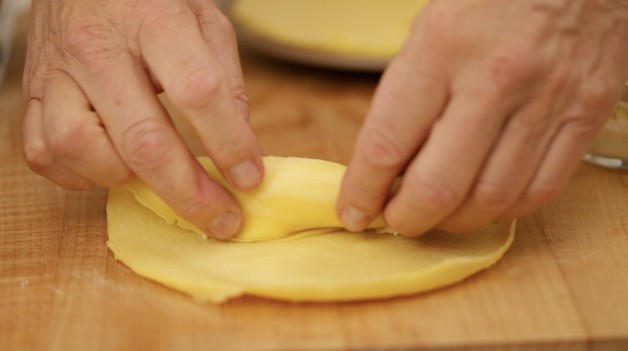 Rolling a crepe with cheese on a cutting board