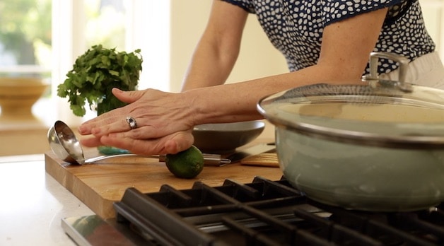 Rolling a lime on a wooden cutting board