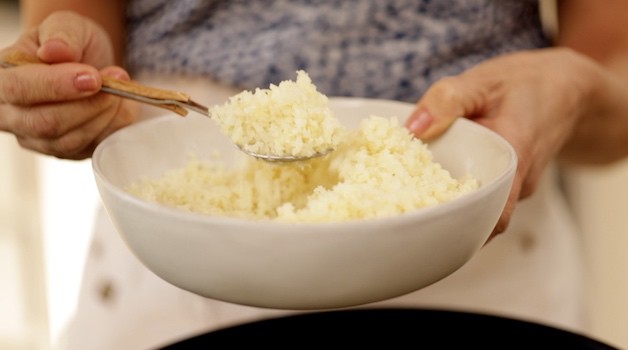 Tight shot of cauliflower rice in a gray bowl