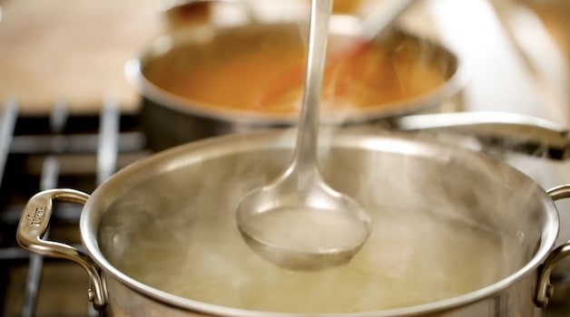 adding pasta water to sun-dried tomato sauce