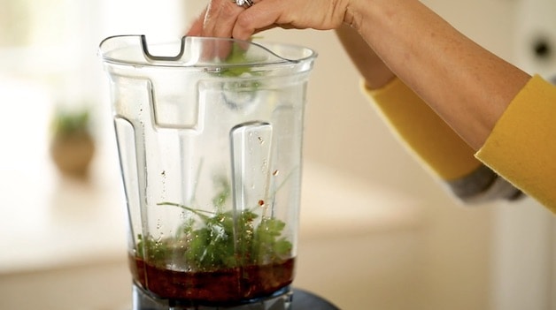 adding parsley to sun-dried tomato pesto in blender