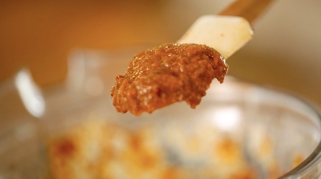 Tight shot of sun-dried tomato pesto on a spatula