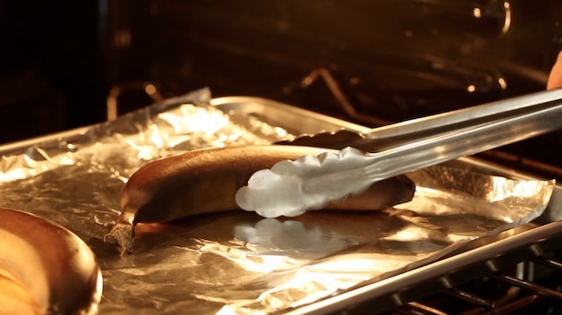 a brown banana in the oven with tongs
