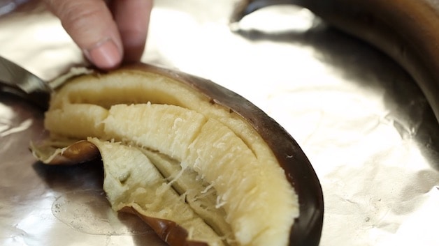 revealing ripe banana flesh in a ripe banana inside a black peel