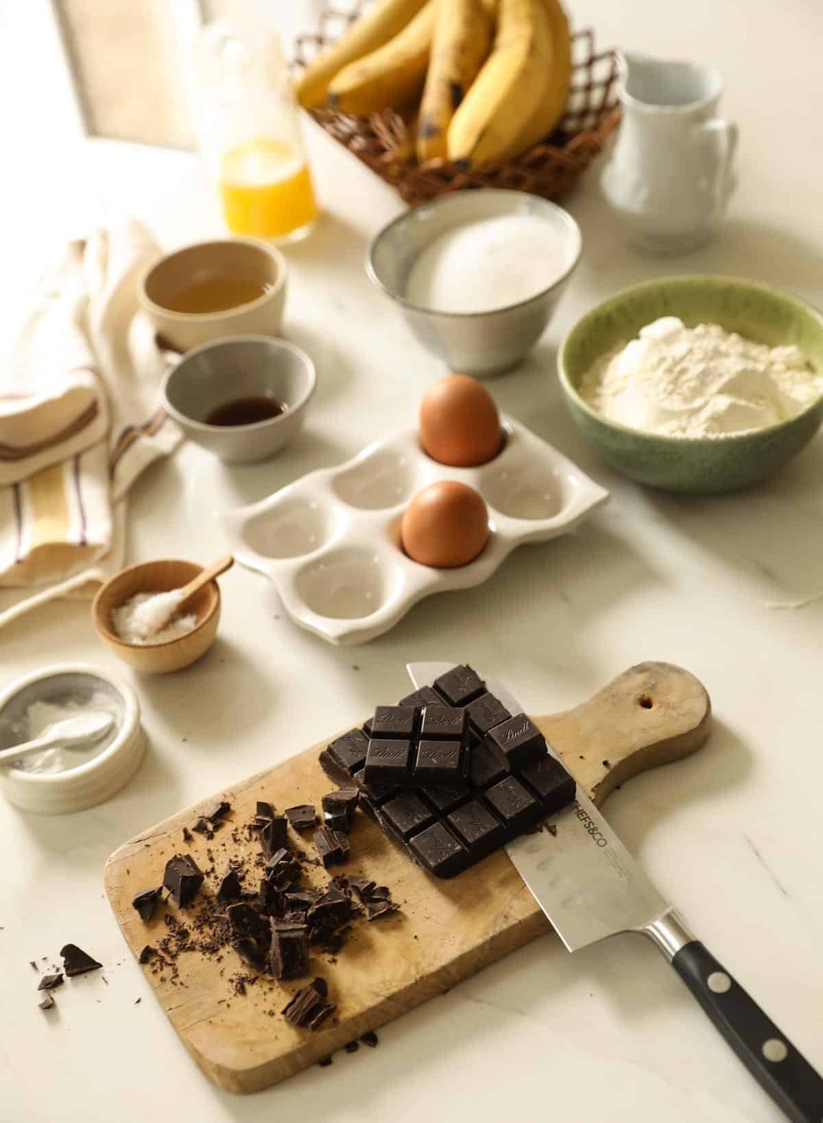 Ingredients for banana muffins with chocolate chunks laid out on a counter.