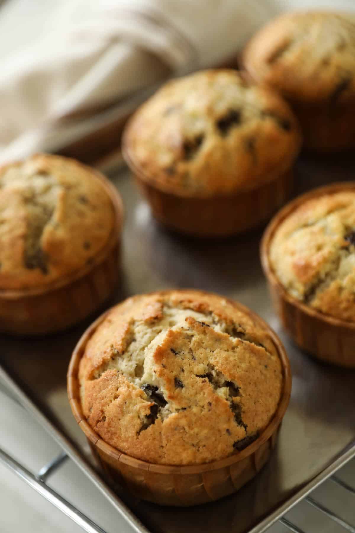 A Chocolate Chunk Banana Muffin cooling on a baking sheet.