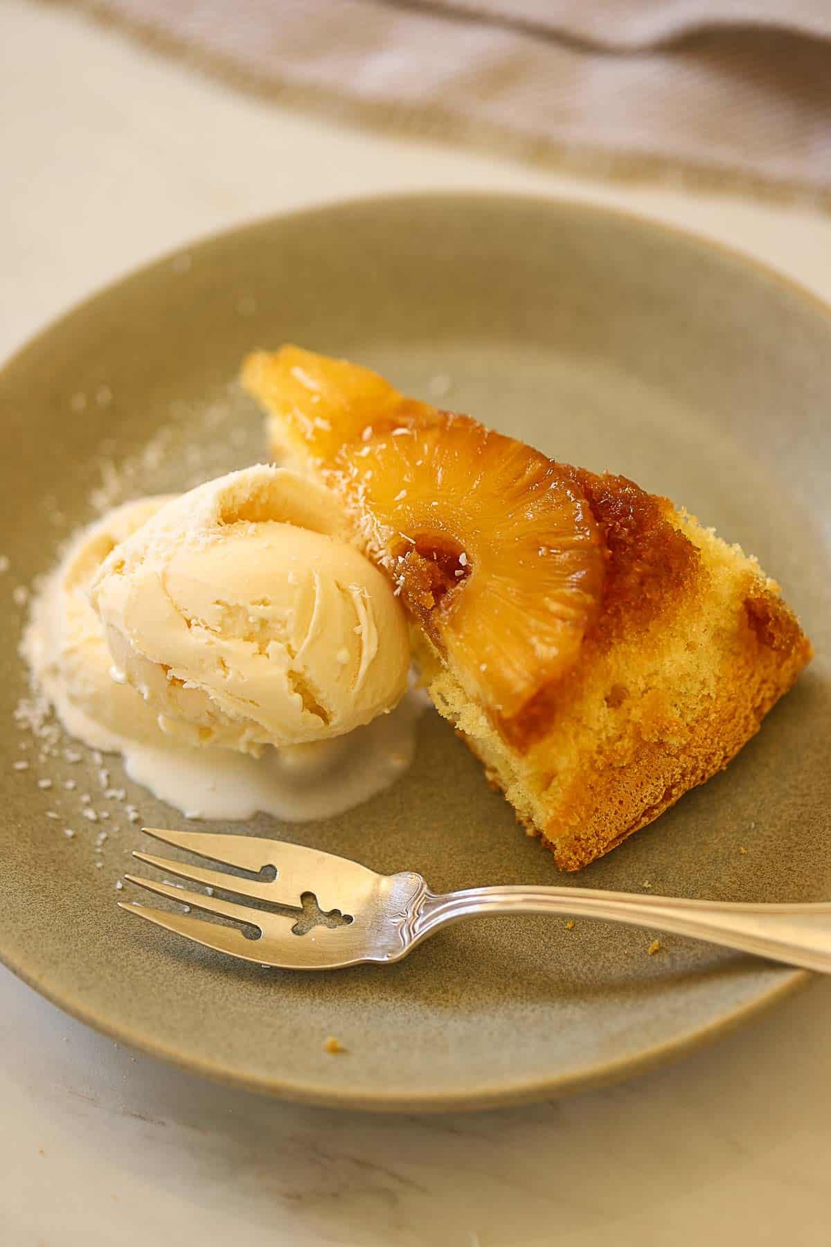 A slice of cake with pineapple on top.