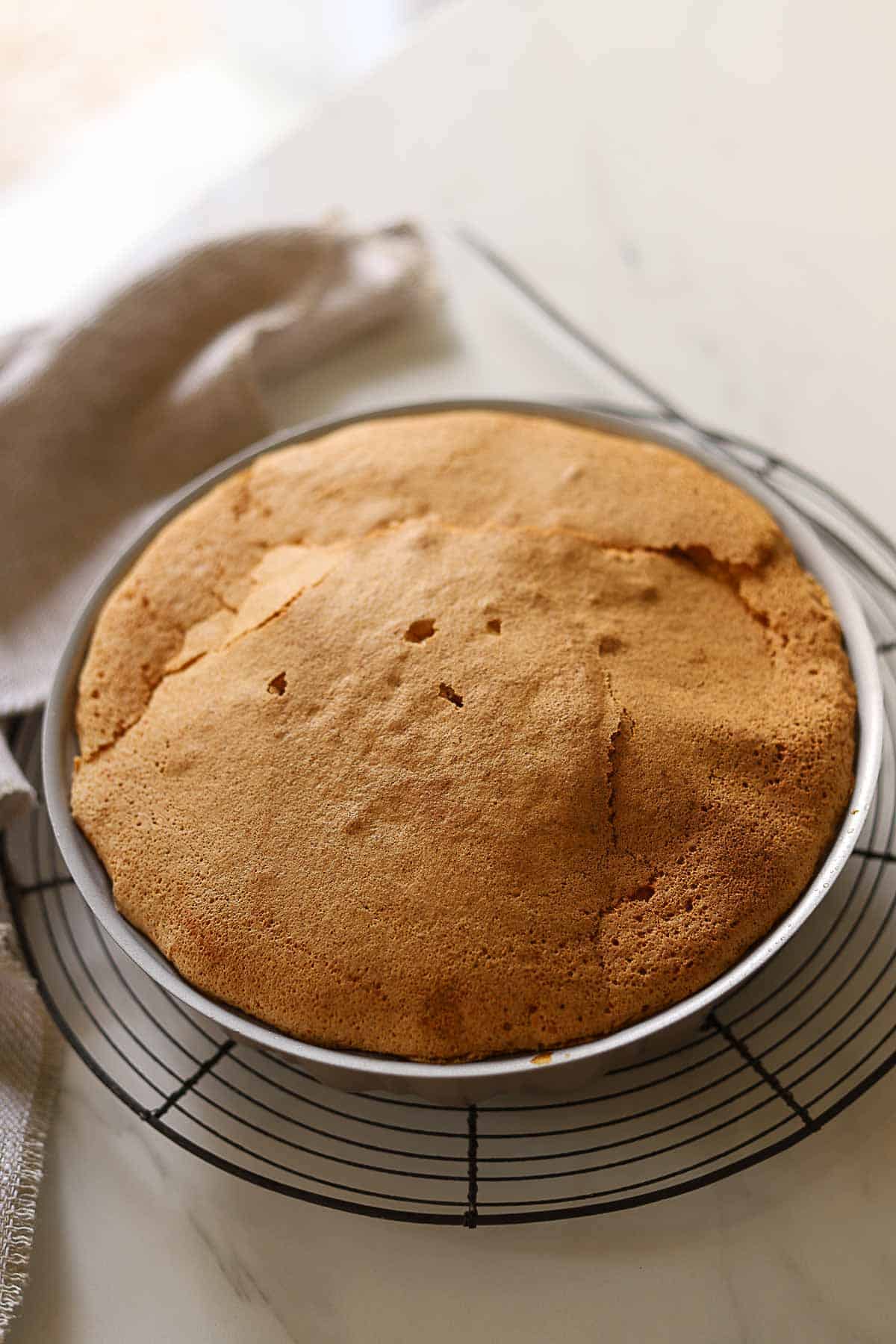 a cake baked and cooling on a cake rack.