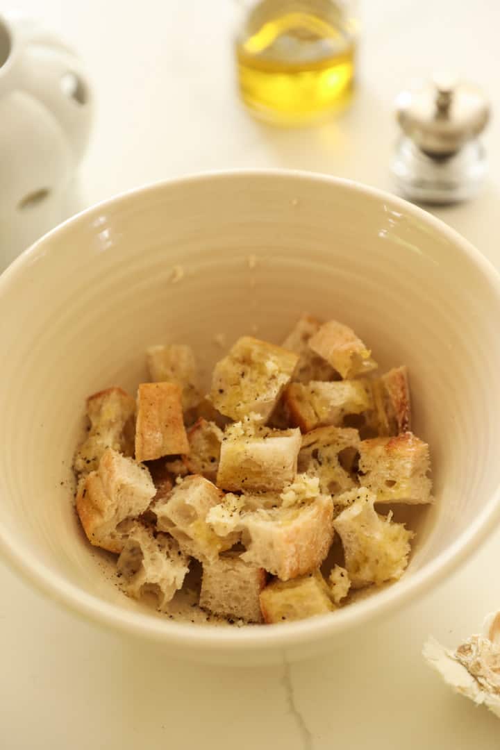 Bread cubes in a bowl with olive oil and garlic