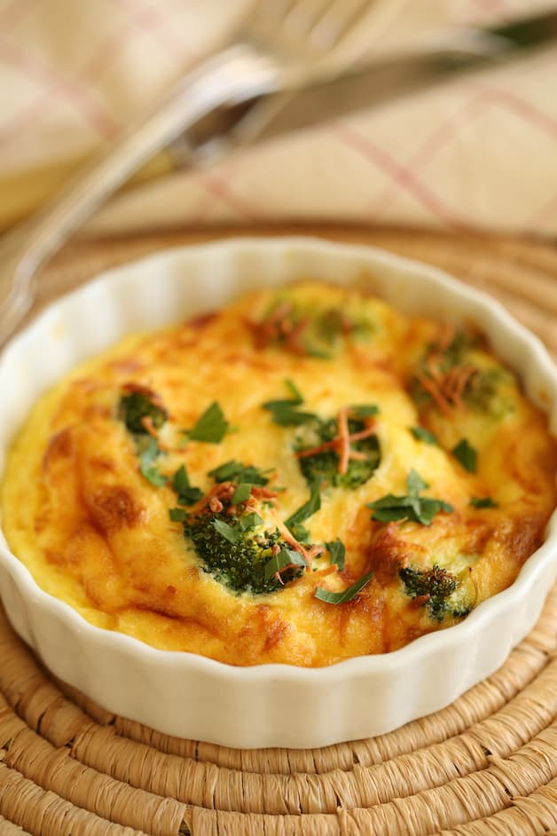 Vertical Image of an air fryer quiche on table with fork and napkin