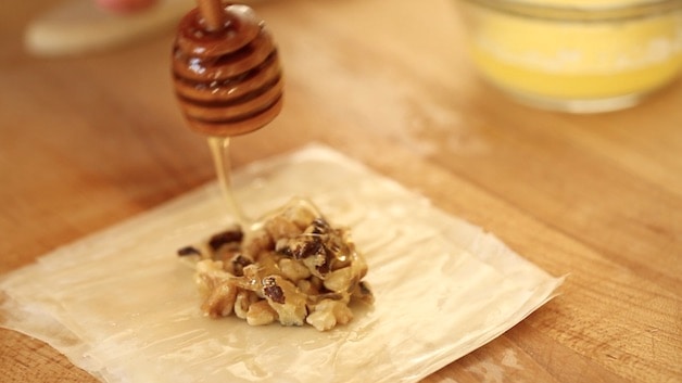 Adding Honey to Walnuts on Filo Dough