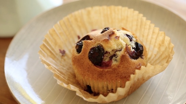 Unwrapped muffin paper revealing a freshly baked air fryer muffin