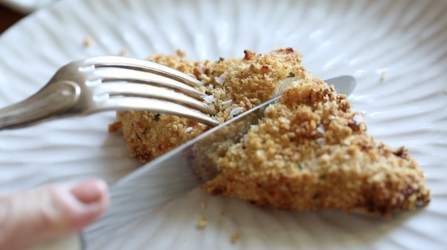 Air Fryer chicken Tender being sliced with a fork and knife on a plate