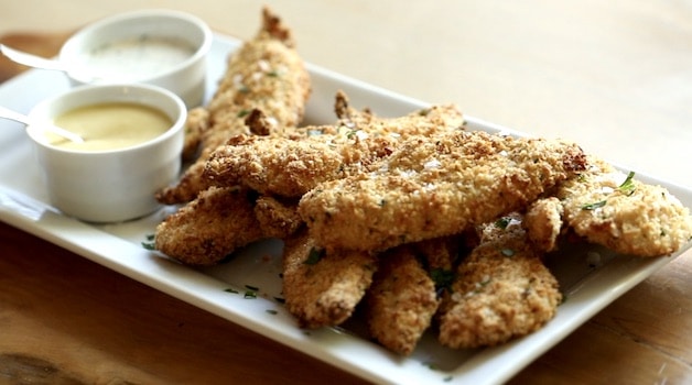 A platter of air fried chicken tenders with dipping sauces