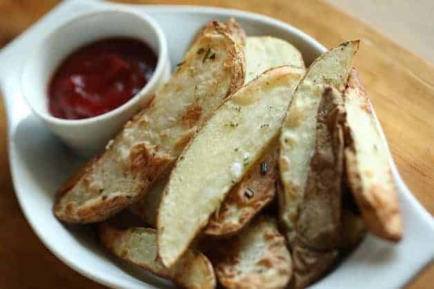 Air Fryer Potato Wedges in a Gratin dish with a small ramekin of ketchup