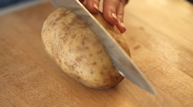 Slicing a russet potato in half