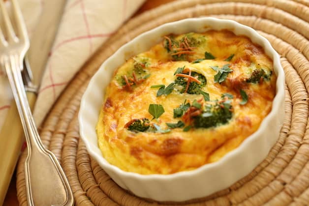 Air Fryer Quiche in a mini white quiche dish on a placemat with fork 