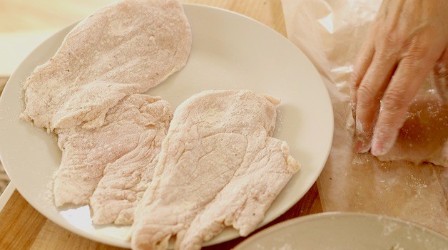 Chicken Breast coated with flour on white plate