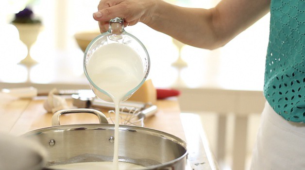 Pouring heavy cream into a skillet