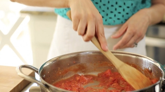 Cooking tomatoes down into a sauce in a skillet