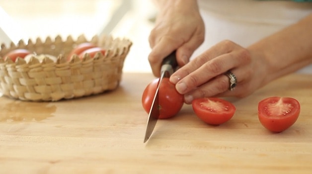 Slicing a Roma tomato in half
