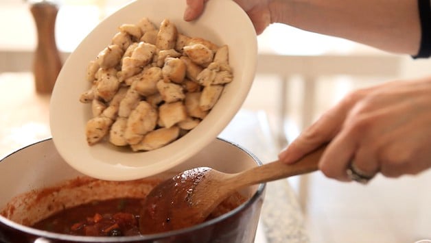 adding cooked chicken into a stew