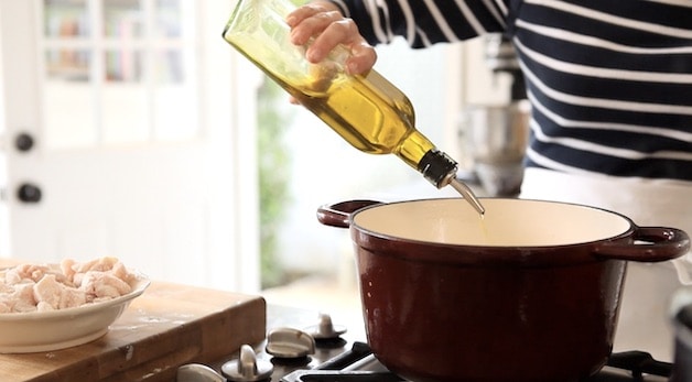 adding olive oil to a Dutch oven
