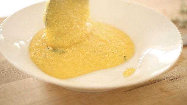 Creamy Polenta being served into a white bowl 