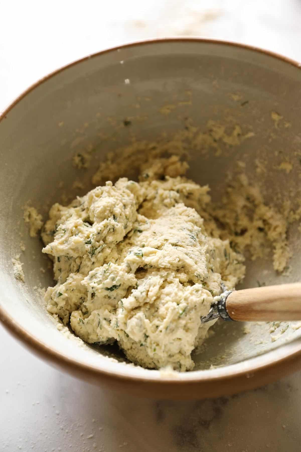 Biscuit dough with herbs in a mixing bowl