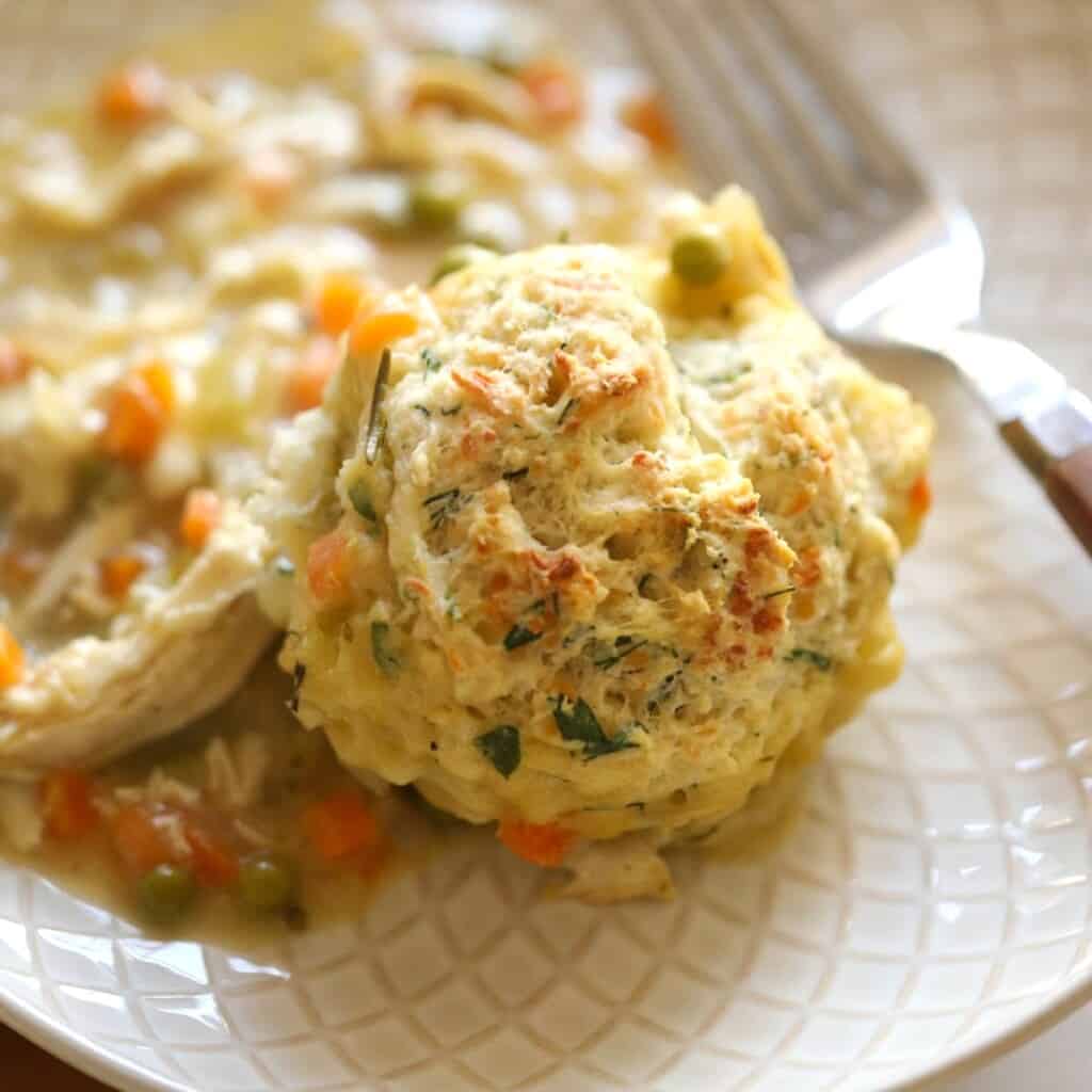 a portion of chicken and biscuits on a plate