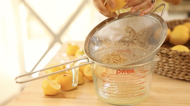 Squeezing lemons over seive and pyrex pitcher