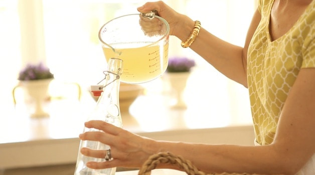 pouring lemonade into a decorative French bottle