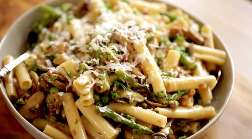 Large bowl of pasta with vegetables and parmesan cheese