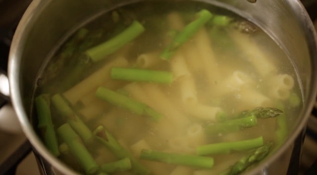 boiling pasta peas and asparagus in a pot of boiling water