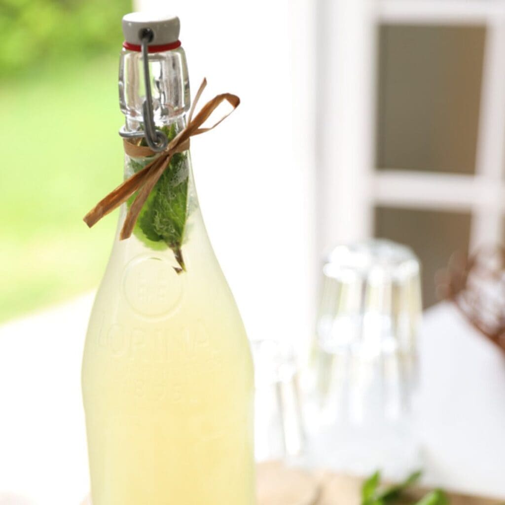 A bottle of homemade lemonade with fresh mint.