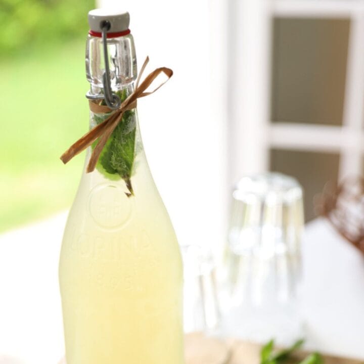 A bottle of homemade lemonade with fresh mint.
