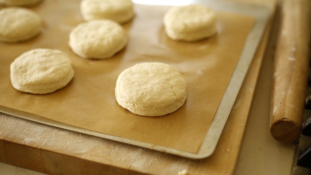 Biscuit dough cut and placed on parchment lined cookie sheet