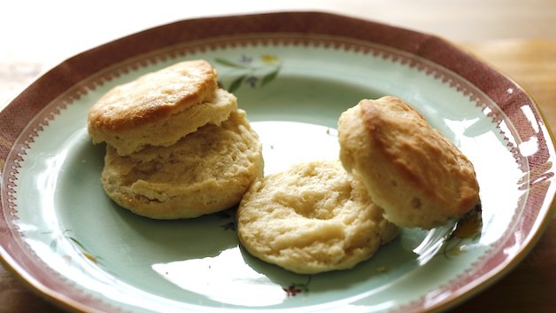 two buttermilk biscuits split open on blue plate