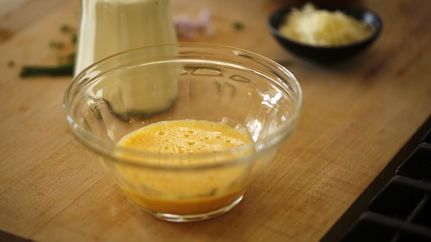 Eggs scrambled in a bowl on a cutting board