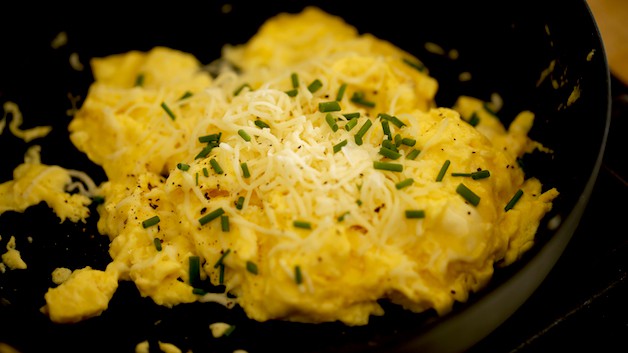 Soft Scrambled Eggs with cheese and chives in a Skillet