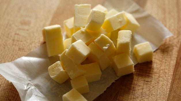 Butter cubes on butter wrapper resting on a cutting board